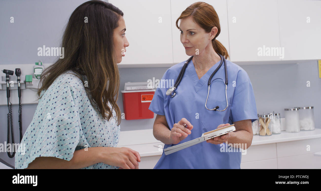 Close up of hispanic patient talking with senior nurse about health Stock Photo