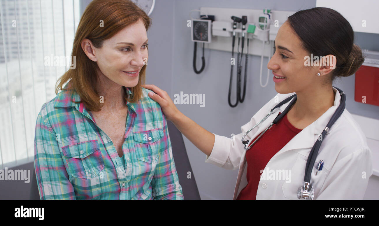 Young latina doctor telling senior patient the good news about her health Stock Photo