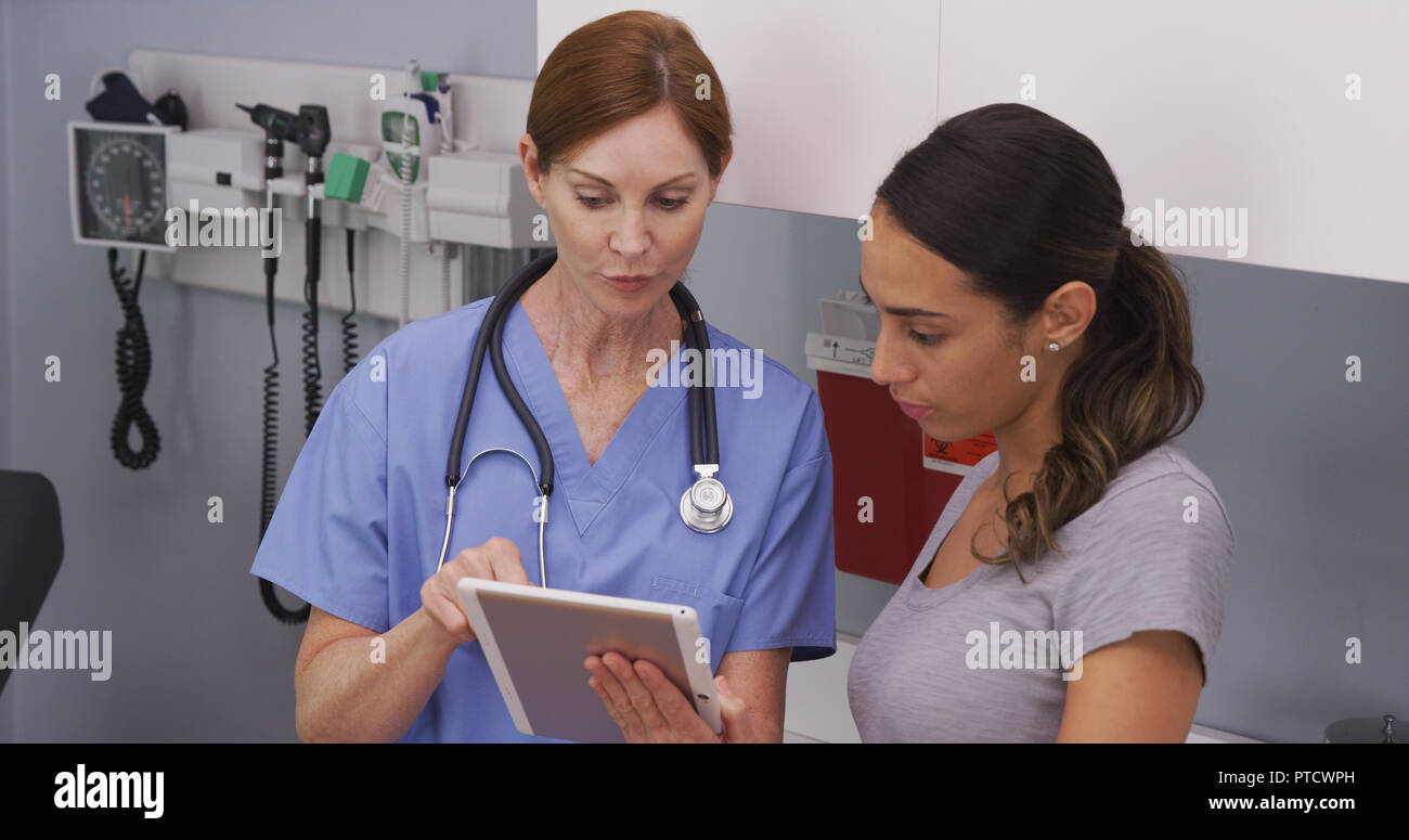 Close up of nurse explaining to young hispanic patient her health condition Stock Photo