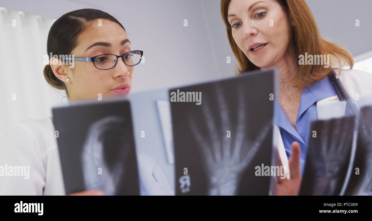 Portrait of 2 medical doctors looking at x rays of patients wrists Stock Photo