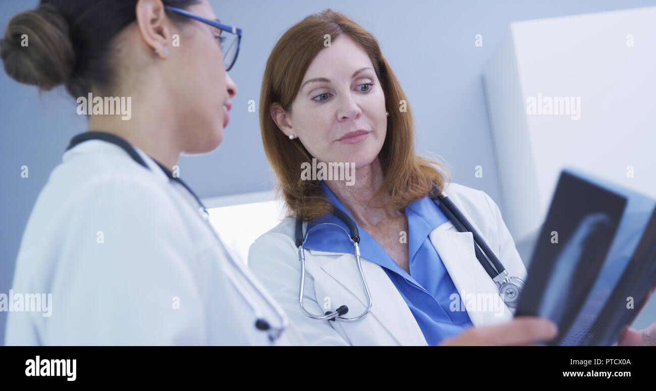 Charming senior medical doctor training younger colleague with xrays of hands Stock Photo
