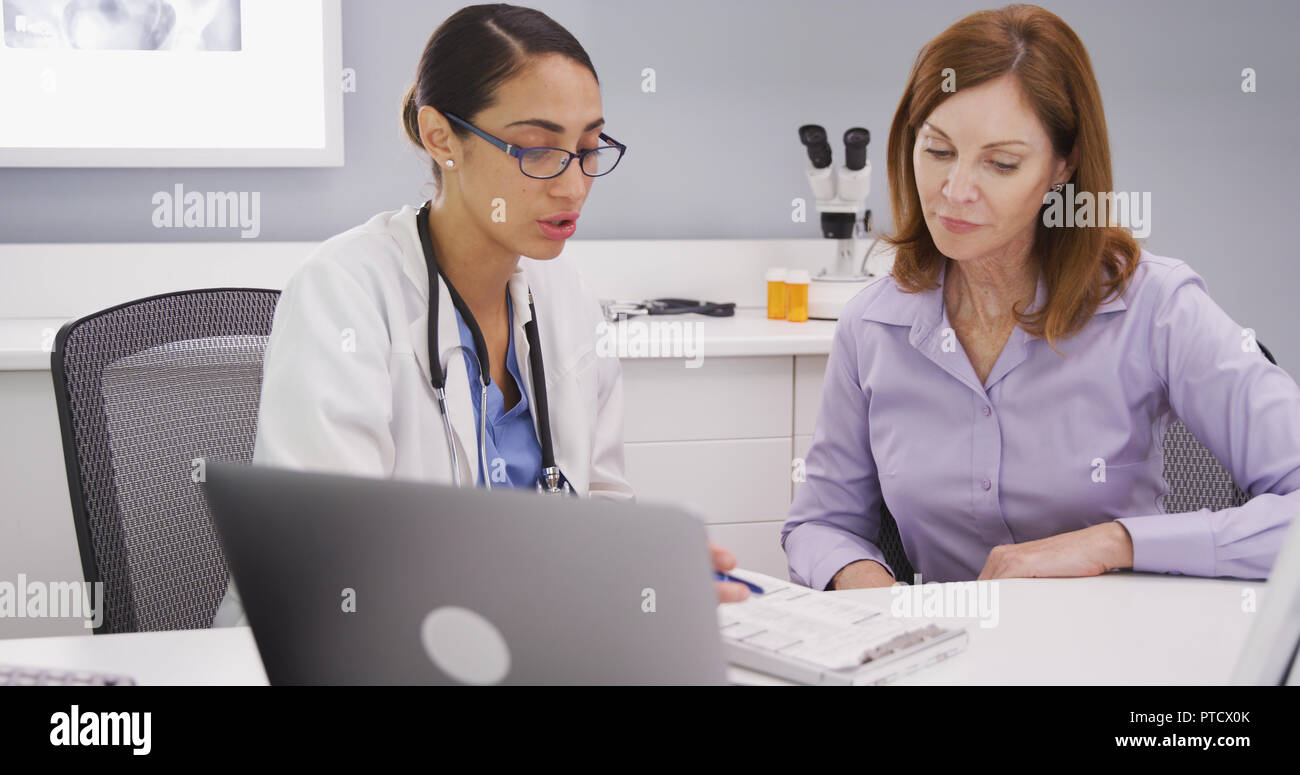 Young female doctor discusses health condition with senior patient in office Stock Photo