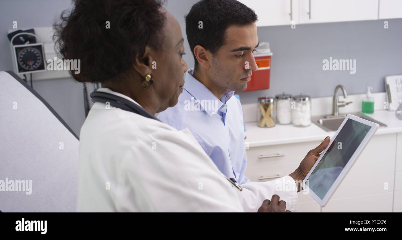 Attractive latino patient looking at x-ray result on electronic notebook tablet Stock Photo