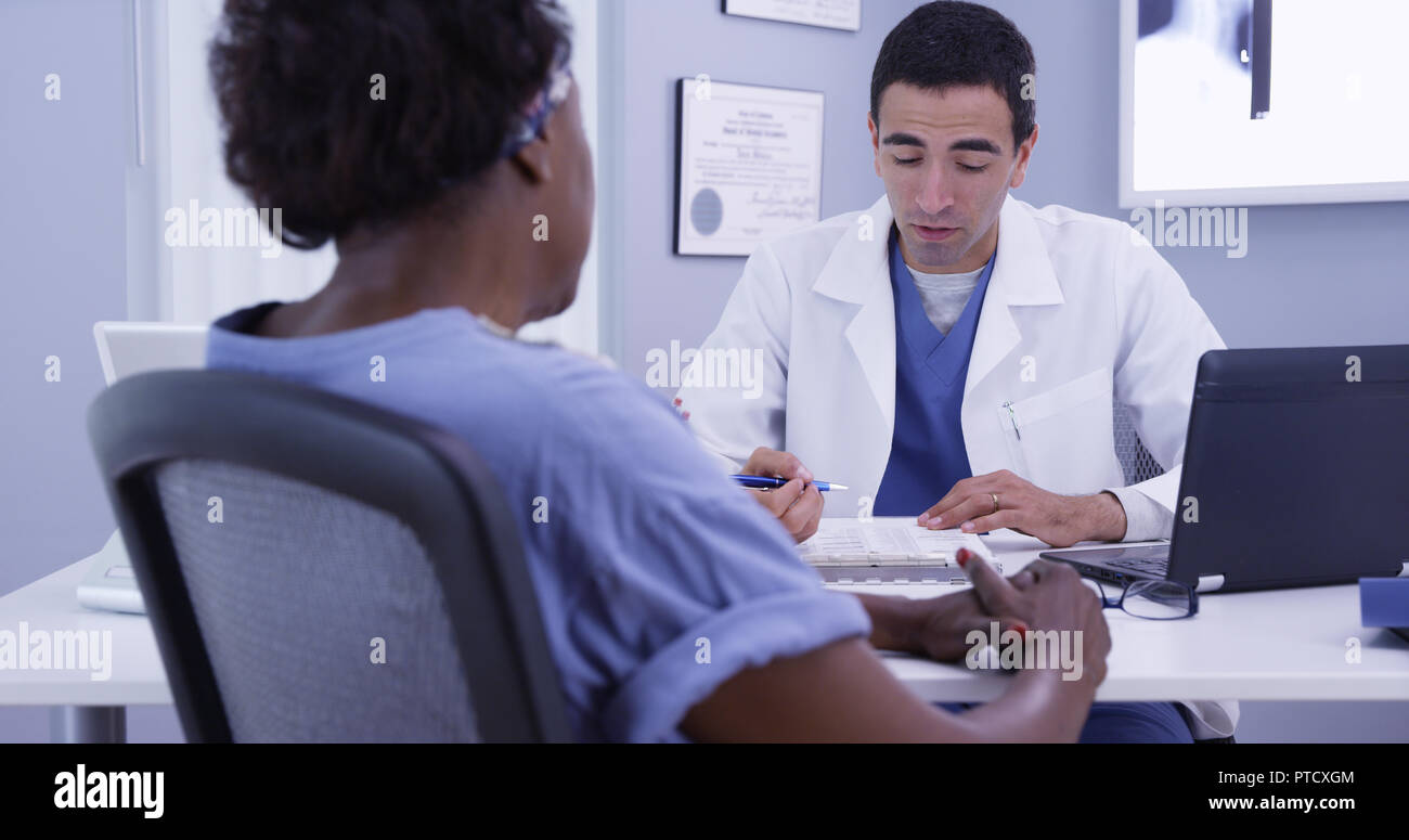 Happy senior patient talking with doctor in medical office about good health Stock Photo