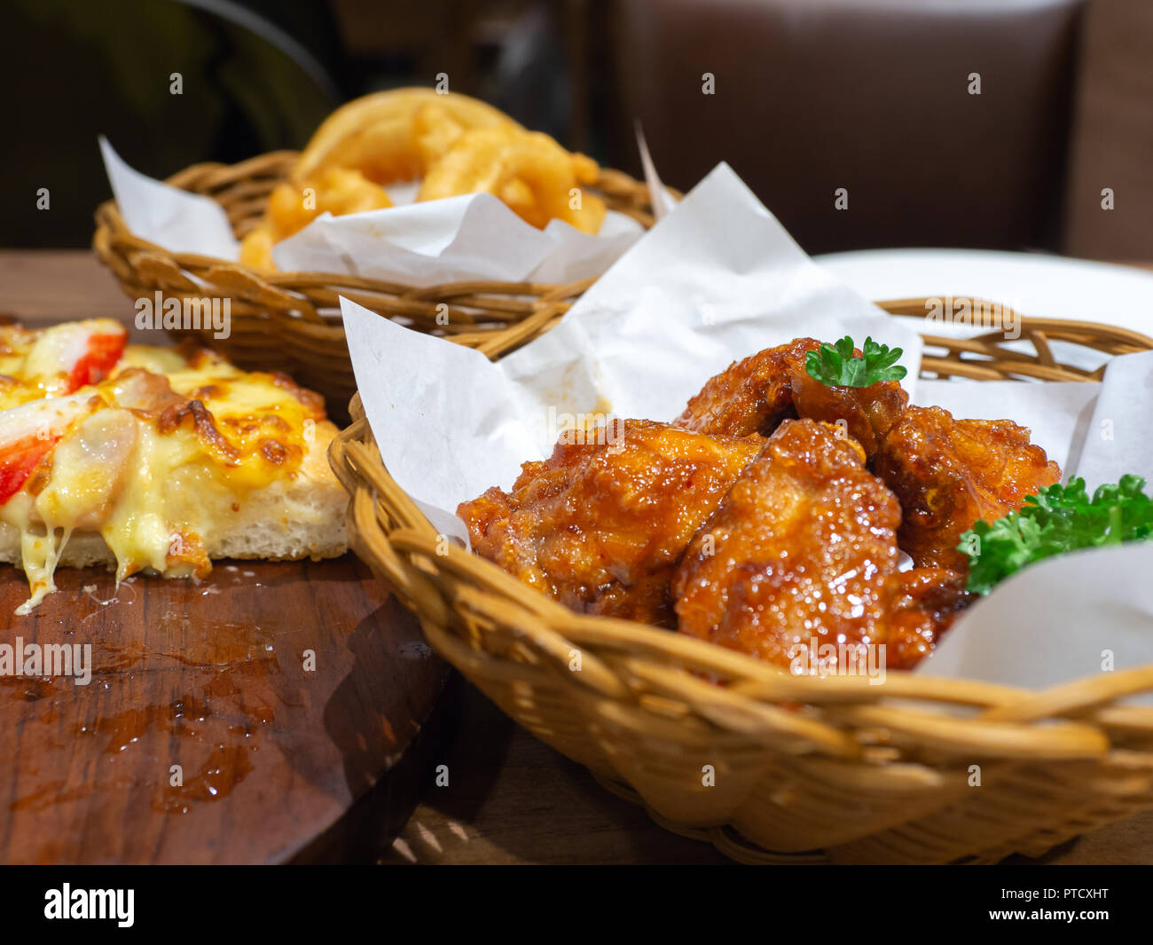 Deep fried chicken in a basket with parsley and seafood pizza topping
