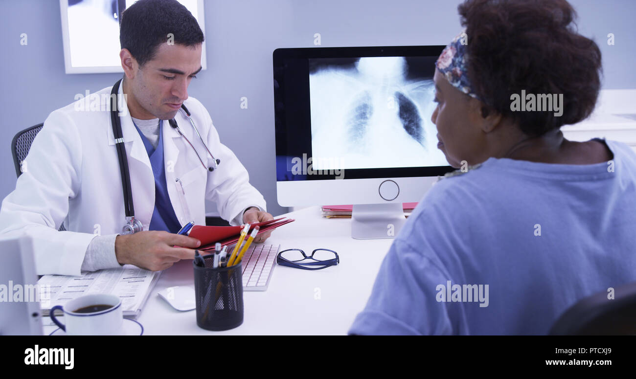 Mid aged black woman checking up with her MD the result of her chest x-ray Stock Photo
