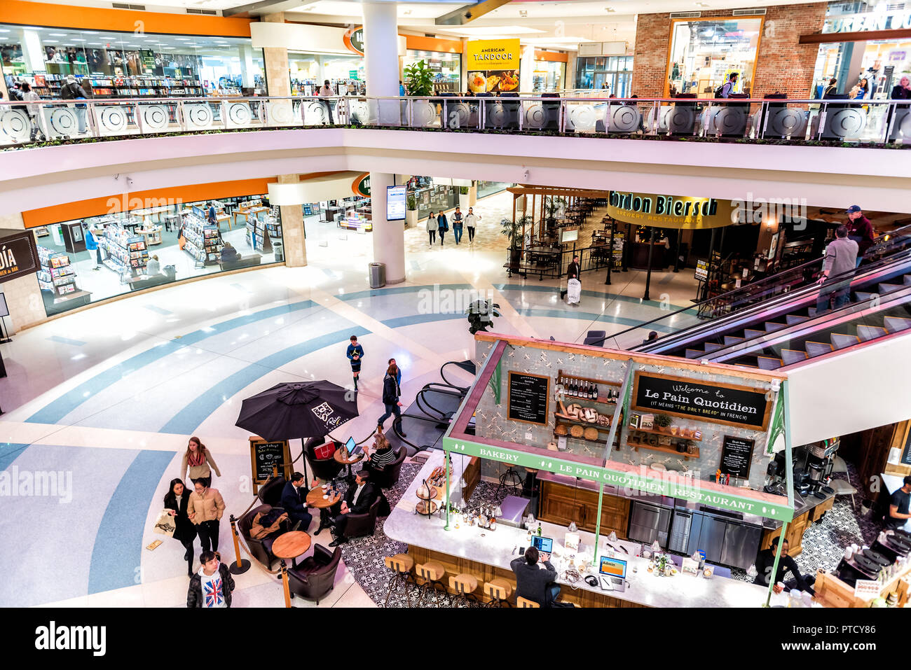 Tysons, USA - January 26, 2018: High angle view on food court with many stores, shops in Tyson's corner shopping mall with people walking, eating, buy Stock Photo
