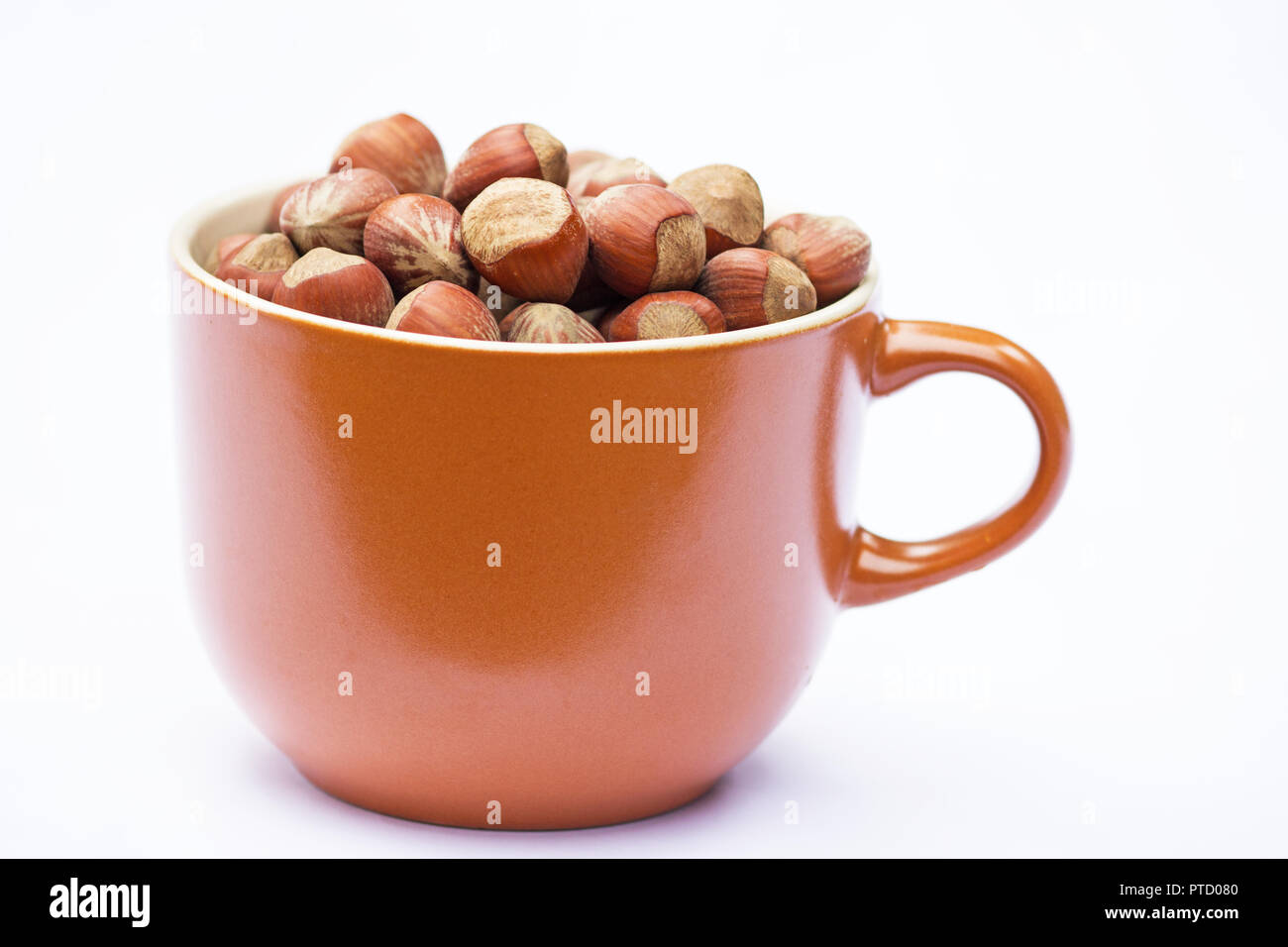 Hazelnuts in a soup bowl, on white background Stock Photo