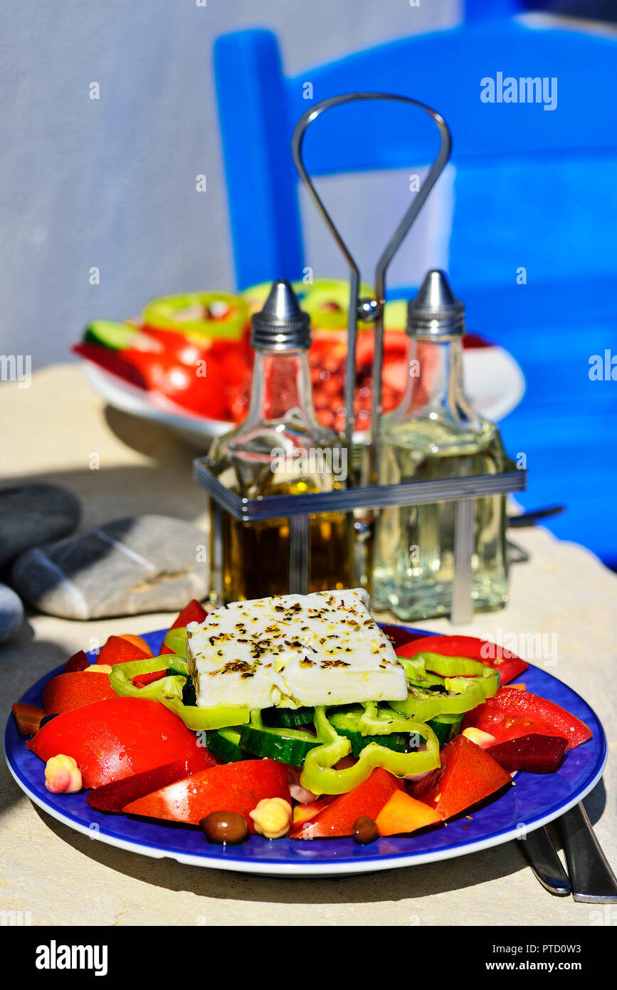 Greek salad with sheep cheese served on plate, vinegar and oil on the back, Greek tavern, mirtos, crete, Greece Stock Photo
