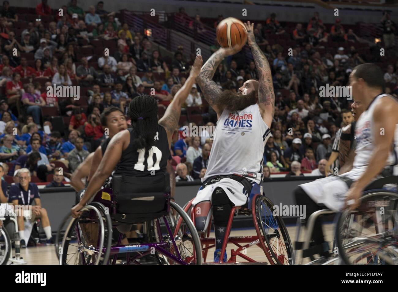(July 7, 2017) Retired Aviation Electrician’s Mate Airman Steve Davis, a native of Modesto, Calif., and member of Team Navy Warrior Games wheelchair basketball team, takes a shot during the championship game against Team Army at the United Center. Team Navy is comprised of athletes from Navy Wounded Warrior - Safe Harbor, the Navy's sole organization for coordinating the non-medical care of seriously wounded, ill, and injured Sailors and Coast Guard members, providing resources and support to their families. Stock Photo