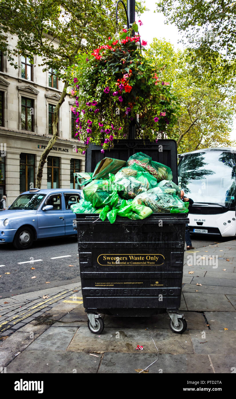 Overcrowded garbage can at the roadside, London, England Stock Photo