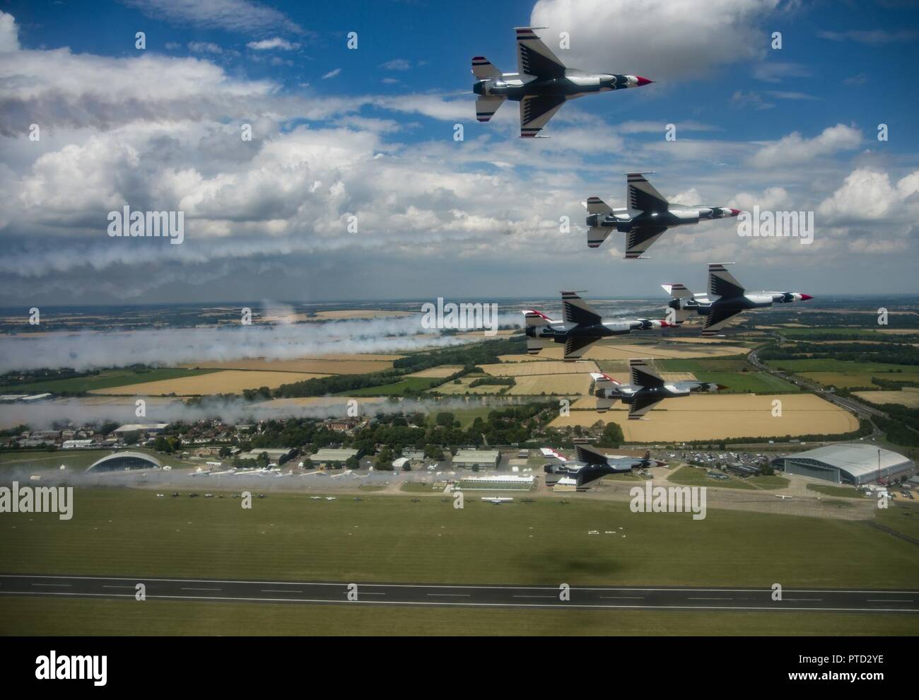 The U.S. Air Force Thunderbirds fly over RAF Duxford, England, July 10, 2017. The Thunderbirds flew over several bases and landmarks in preparation for the 2017 Royal International Air Tattoo being held at RAF Fairford, England. The Air Force is celebrating its 70th Anniversary in 2017. Stock Photo
