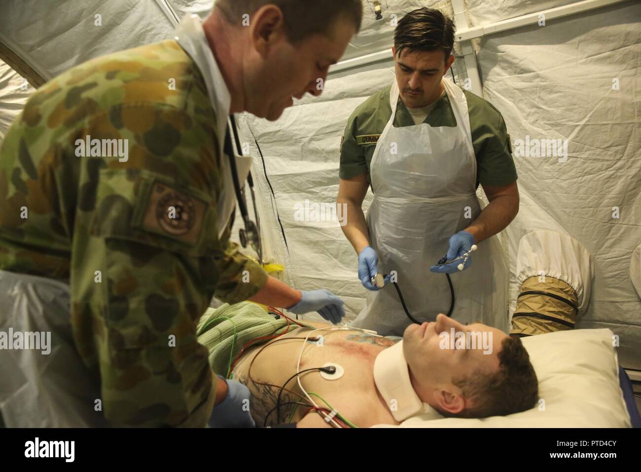 Major Paddy Bates, a trauma nurse with 3rd Health Support Battalion, 17th Combat Service Support Brigade, and Corporal James Gummow, a medic with 2nd General Health Battalion, 17th CSS Brigade, evaluate a patient with a simulated sternum fracture during a mass casualty exercise at Williamson Air Field, Shoalwater Bay Training Area, Queensland, Australia, July 8, 2017 during Talisman Saber 17. Australian Army soldiers with 17th CSS Brigade conducted a mass-casualty exercise at Williamson Air Field hospital to practice Role 2 advanced trauma care and procedures that are used in a deployed enviro Stock Photo