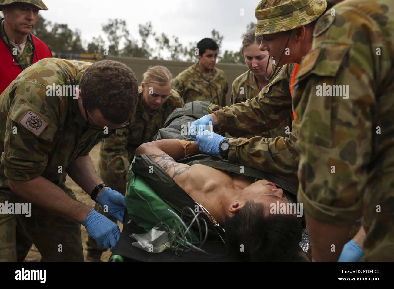 Australian Army medics with 17th Combat Service Support Brigade evaluate a patient with a simulated gunshot wound during a mass casualty exercise at Williamson Air Field, Shoalwater Bay Training Area, Queensland, Australia, July 8, 2017 during Talisman Saber 17. Soldiers with 17th CSS Brigade conducted a mass-casualty exercise at Williamson Air Field hospital to practice Role 2 advanced trauma care and procedures that are used in a deployed environment. Exercises like Talisman Saber provide effective and intense training to ensure our forces are capable, interoperable, deployable on short noti Stock Photo