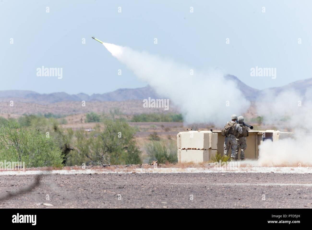 U.S. Marine Corps Lance Cpl. Spenser Ricks (right) and Sgt. Johnathon Moore,  Low Altitude Air Defense (LAAD) gunners with 3rd LAAD Battalion, Marine Air Control Group 38 (MACG-38), 3rd Marine Aircraft Wing (3D MAW) fire a FIM-92 Stinger surface-to-air missile during a live fire exercise at Yuma Proving Grounds, Yuma, Ariz., July 8, 2017. 3rd LAAD Battalion conducted the exercise in order to maintain proficiency and accuracy with the FIM-92 Stinger. Stock Photo