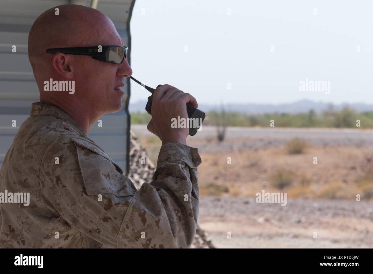 U.S. Marine Corps Gunnery Sgt. Justin Poole, a training chief with 3rd Low Altitude Air Defense (LAAD) Battalion, Marine Air Control Group 38 (MACG-38), 3rd Marine Aircraft Wing (3D MAW) talks on the radio during a stinger live fire exercise at Yuma Proving Grounds, Yuma, Ariz., July 8, 2017. 3rd LAAD Battalion conducted the exercise in order to maintain proficiency and accuracy with the FIM-92 Stinger. Stock Photo