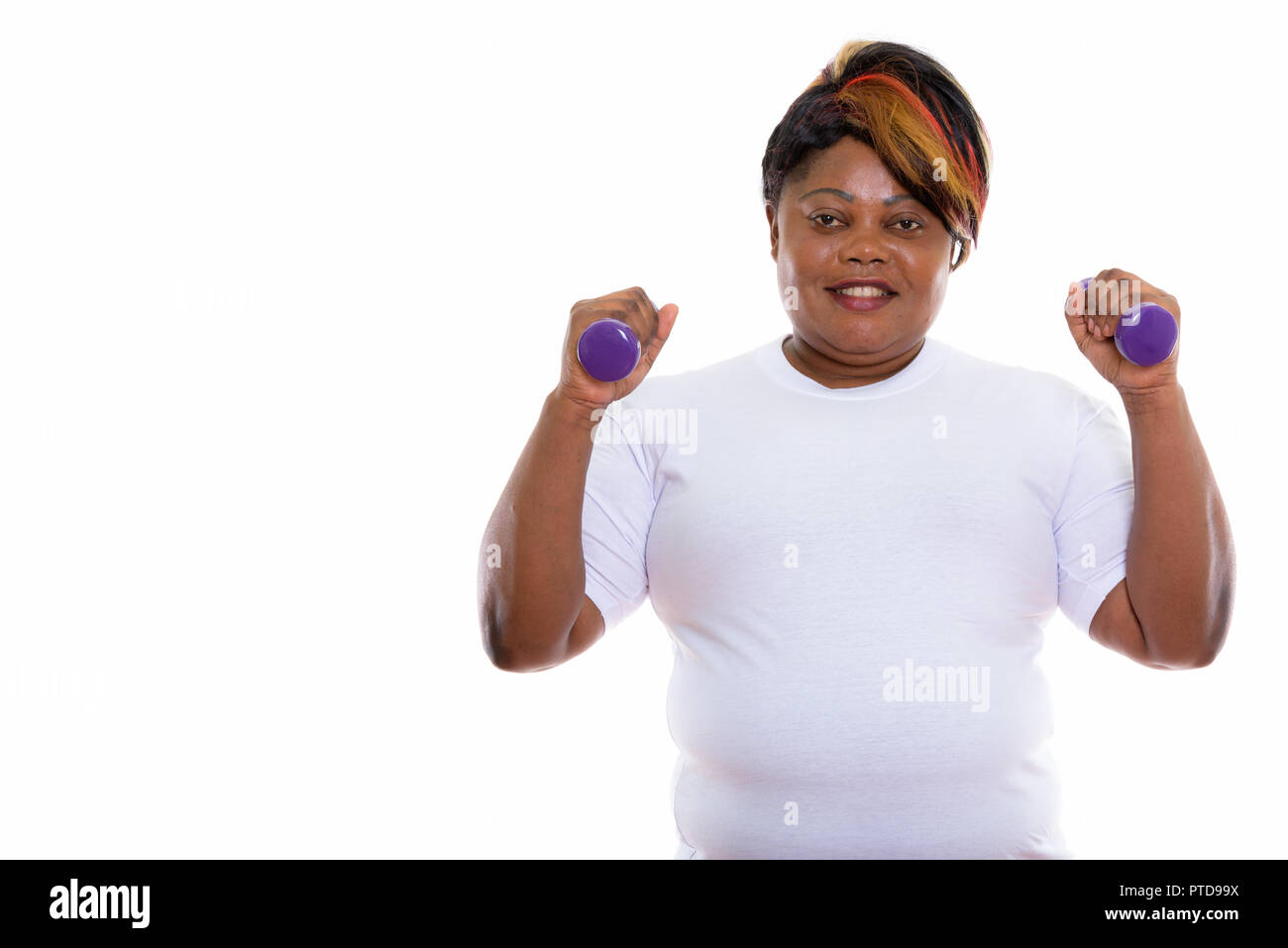 Studio shot of happy fat black African woman smiling while holdi Stock Photo