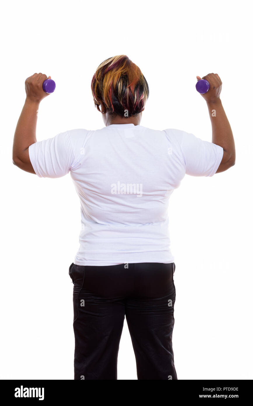Back view of fat black African woman with both dumbbells raised  Stock Photo
