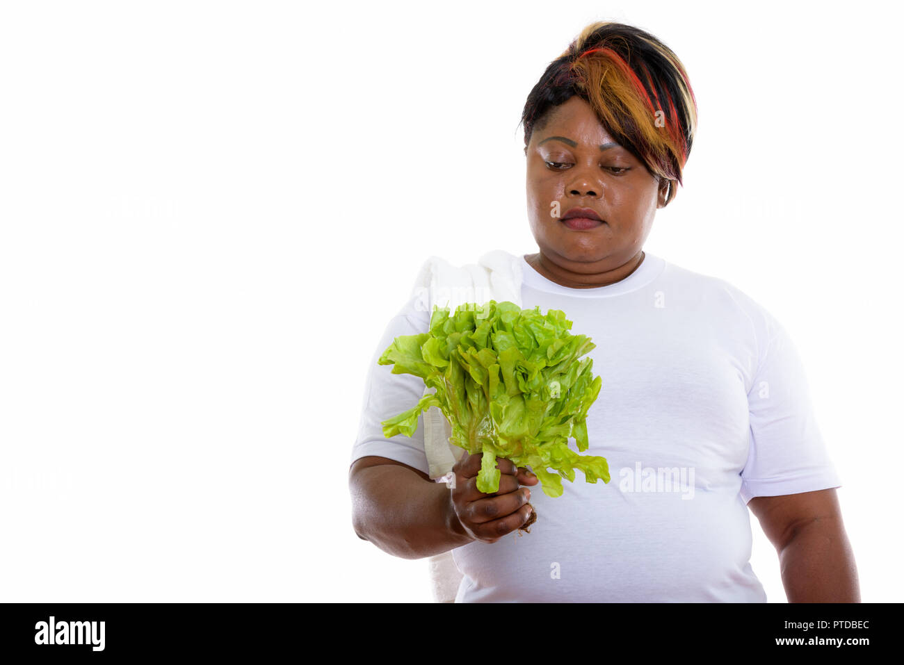 Studio shot of fat black African woman holding and looking at le Stock Photo