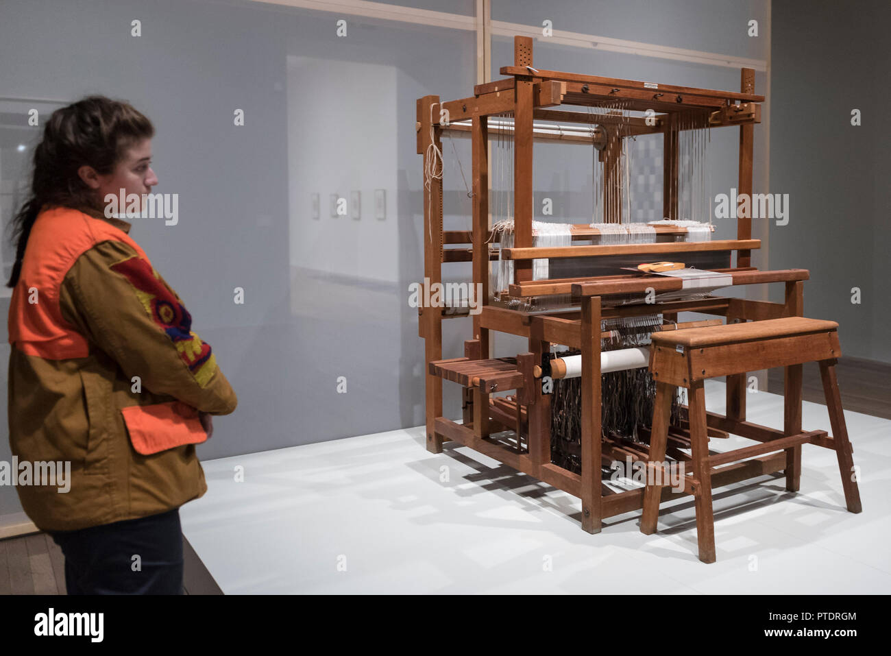 London, UK. 9 October 2018. A staff member views a 12 Shaft Counter March  Loom, 1950s, similar to one used by Anni Albers and fellow students at the  Bauhaus weaving workshop. Preview