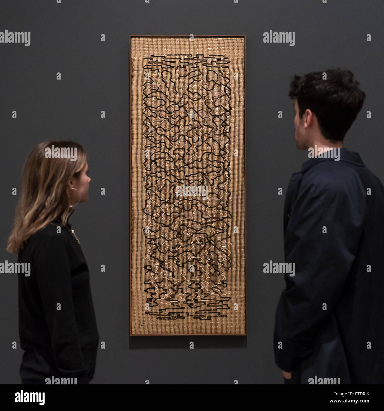 London, UK.  9 October 2018. Visitors view "Epitaph", 1968, by Anni Albers.  Preview of the UK's first exhibition of works by German artist Anni Albers at Tate Modern who used the ancient art of hand-weaving to produce works of modern art.  Over 350 of her artworks from major collections from Europe and the US are on show 11 October to 27 January 2019.  Credit: Stephen Chung / Alamy Live News Stock Photo