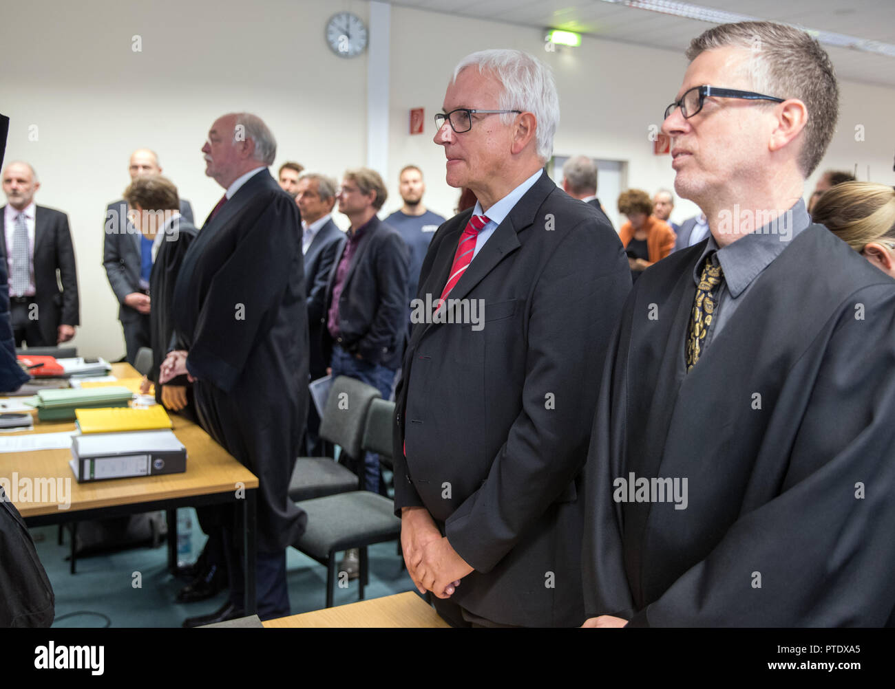 09 October 2018, Berlin: Jürgen Resch (M), the Federal Managing Director of Deutsche Umwelthilfe (DUH), is standing next to the lawyer Peter Kremer (r) at the beginning of the oral hearing on diesel driving bans. The court is negotiating possible diesel driving bans in the capital. On many streets in Berlin the limit value for harmful nitrogen dioxide is exceeded. Photo: Jens Büttner/dpa-Zentralbild/dpa Stock Photo