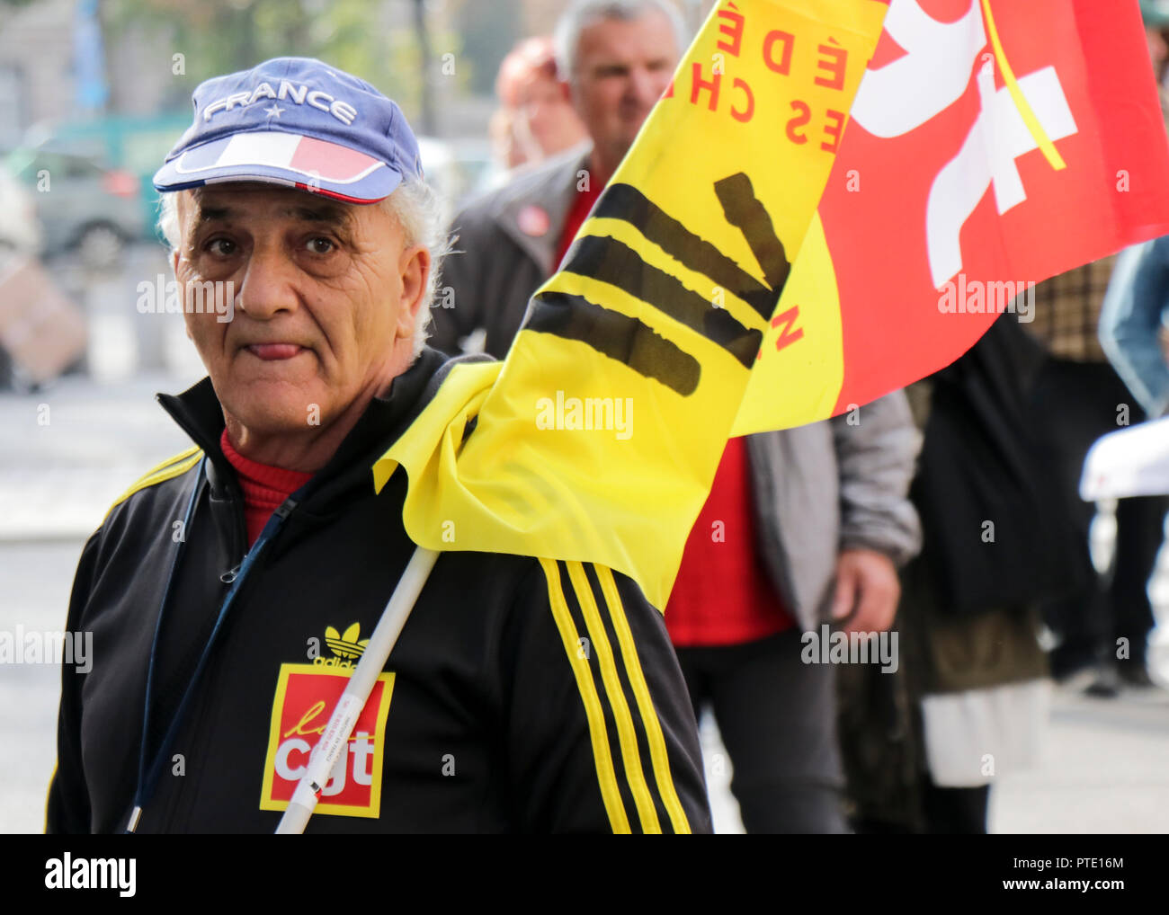 An elderly man seen holding a flag during the protest. People demonstrate during a one-day nationwide strike over French President Emmanuel Macron's policies in Strasbourg, eastern France. Stock Photo