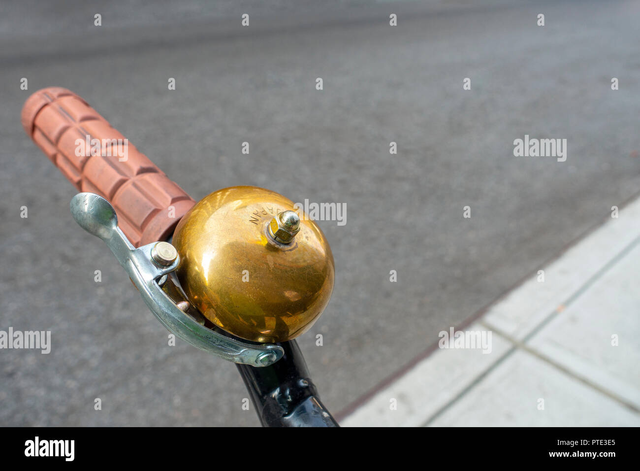 copper bronze bell on the handle bards of a parked bicycle Stock Photo