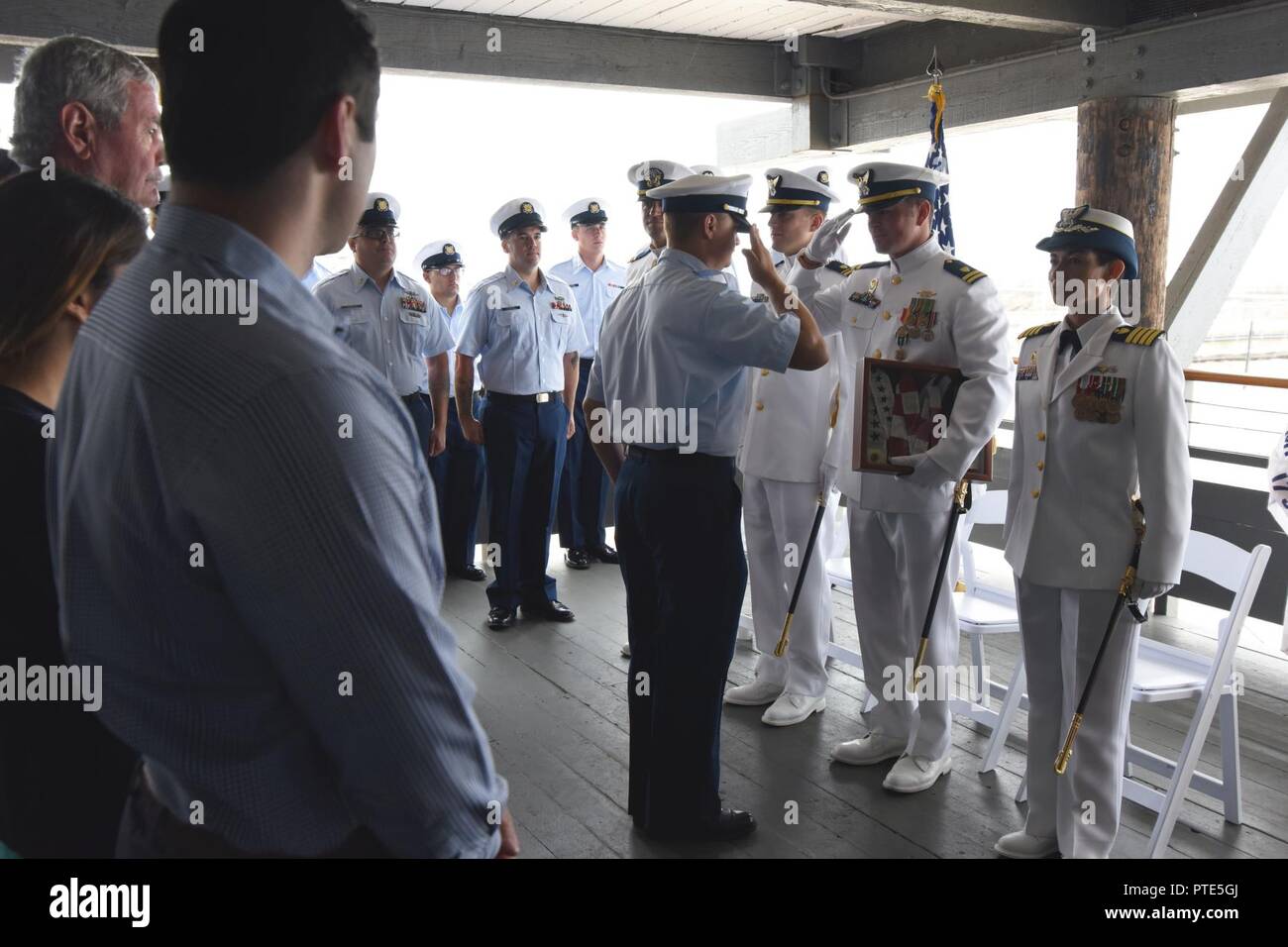 Members of the Coast Guard Cutter Blackfin present Lt. Edward Kalankiewicz with the cutter Blackfin's commissioning pennant at the Blackfin's change-of-command ceremony, July 14, 2017, Santa Barbara, Calif. In change-of-command ceremonies the old commissioning pennant is lowered from the warship's masthead  and presented to the prior commanding officer as they depart, and a new one is put up. U.S. Coast Guard Stock Photo