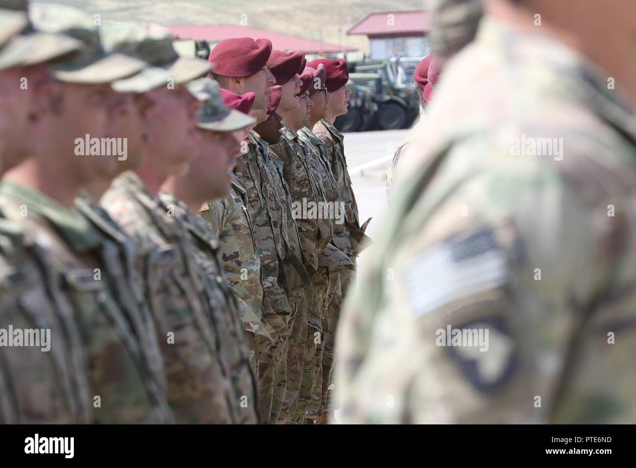 Soldiers from 1st Squadron, 33rd Cavalry, 101st Airborne Division (Air Assault) and 3rd Battalion, 319th Airborne Field Artillery Regiment, 82nd Airborne Division sing “The Army Goes Rolling Along” during a Transfer of Authority ceremony for the Multinational Battle Group-East Forward Command Post July 15, 2017 at Camp Marechal de Lattre De Tassigny (CMLT), Kosovo. Stock Photo