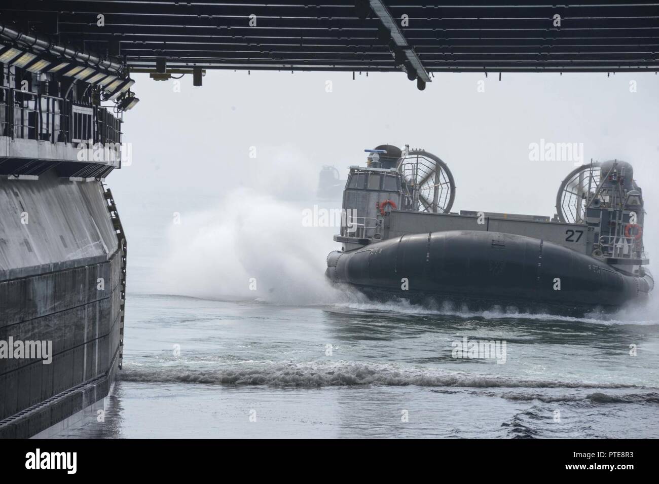 OCEAN (July 15, 2017) Sailors assigned to Assault Craft Unit (ACU) 5 pilot a Landing Craft Air Cushion (LCAC) into the well deck of the Wasp-class amphibious assault ship USS Essex (LHD 2). Essex is underway conducting sea trials off the coast of Southern California. Stock Photo