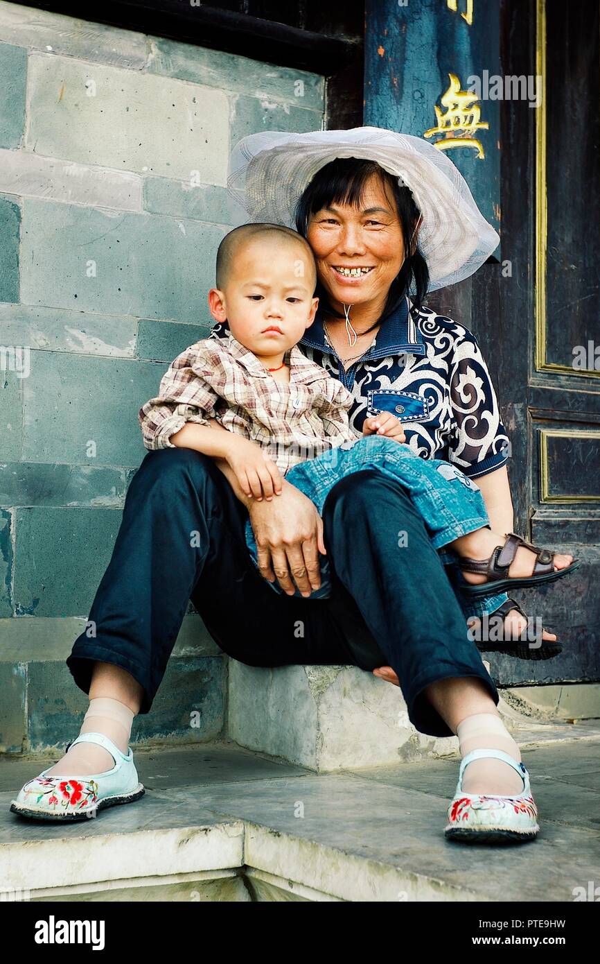 Beijing / China - JUN 24 2011: young mother with her kid in front of the gates of a temple Stock Photo