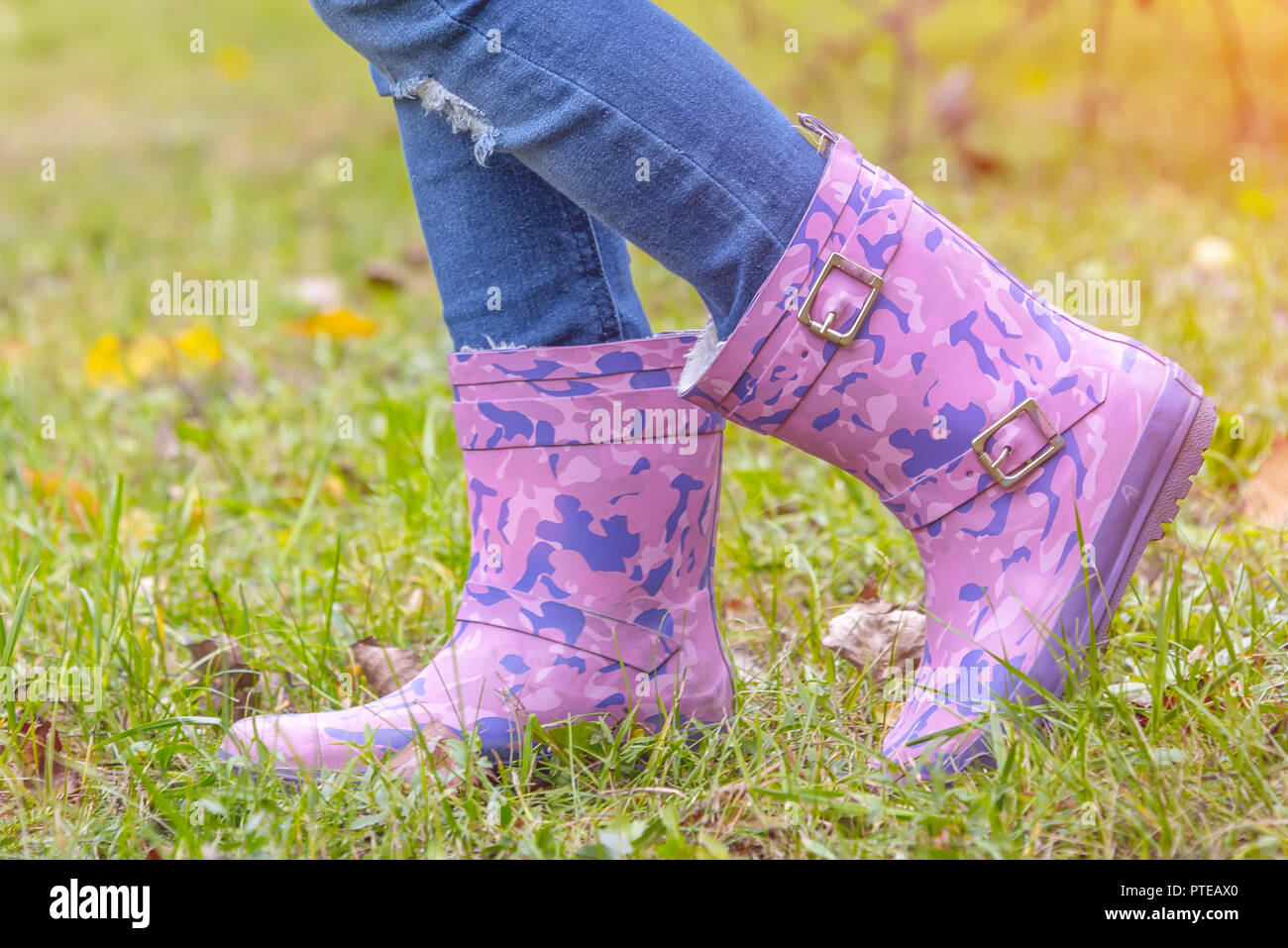 children's feet in rubber boots on yellowed dry grass in autumn Stock ...