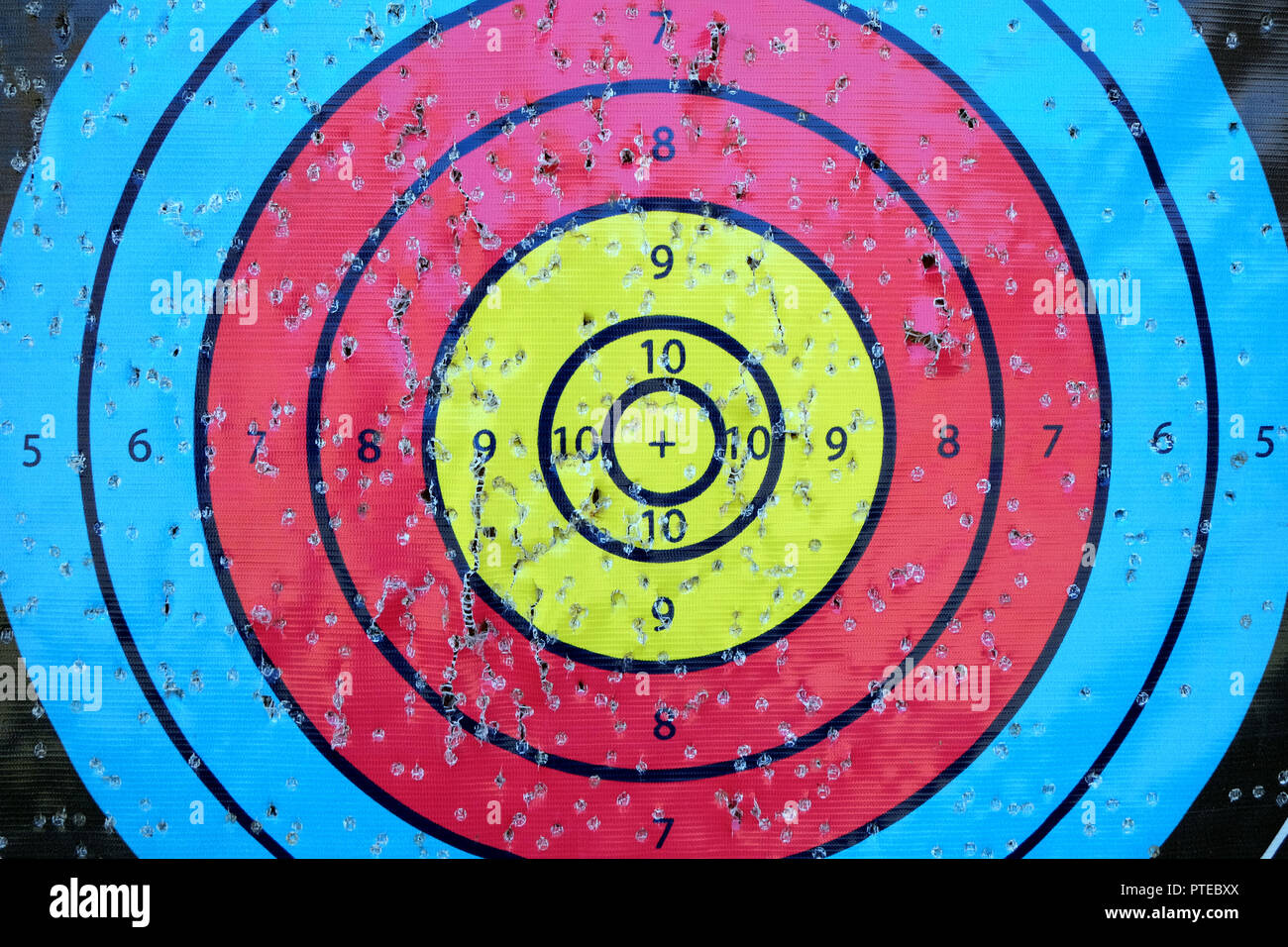 Archery target close up with many arrow holes in gold red blue and