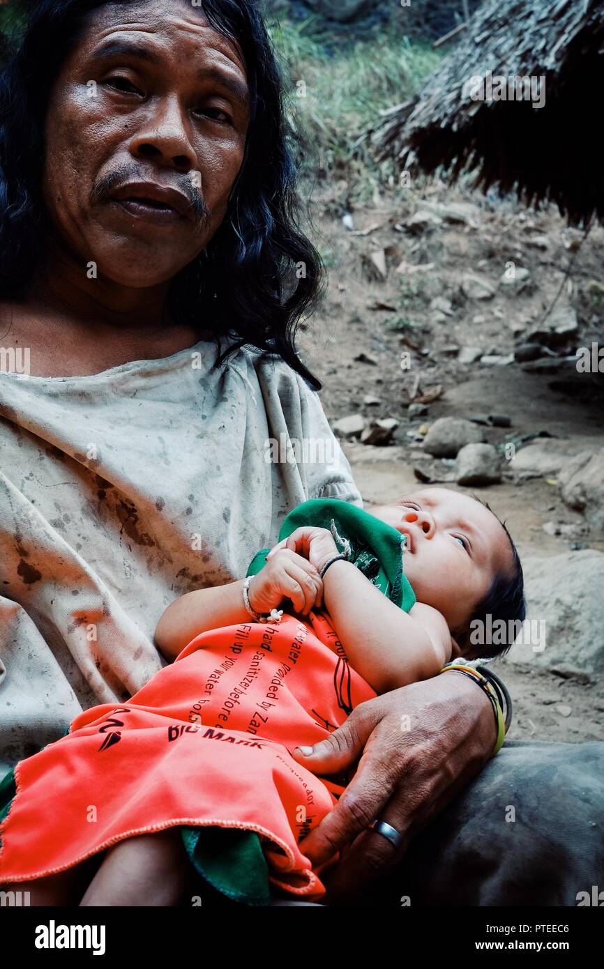 Santa Marta, Magdalena / Colombia - MARCH 10 2016 : kogi tribal member man with his new born son in front of their cloudforest home Stock Photo