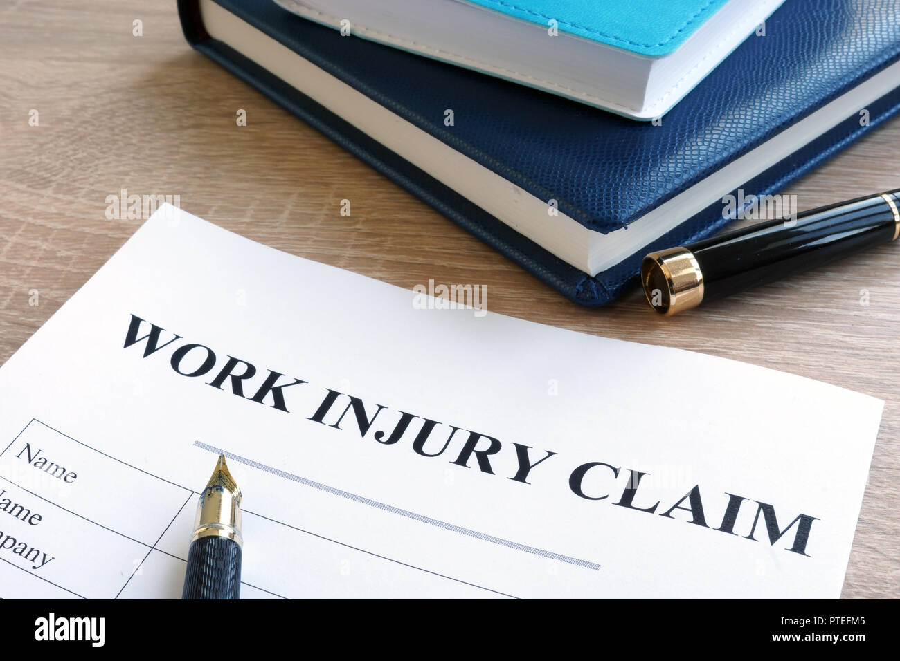 Work injury claim form and note pad. Stock Photo