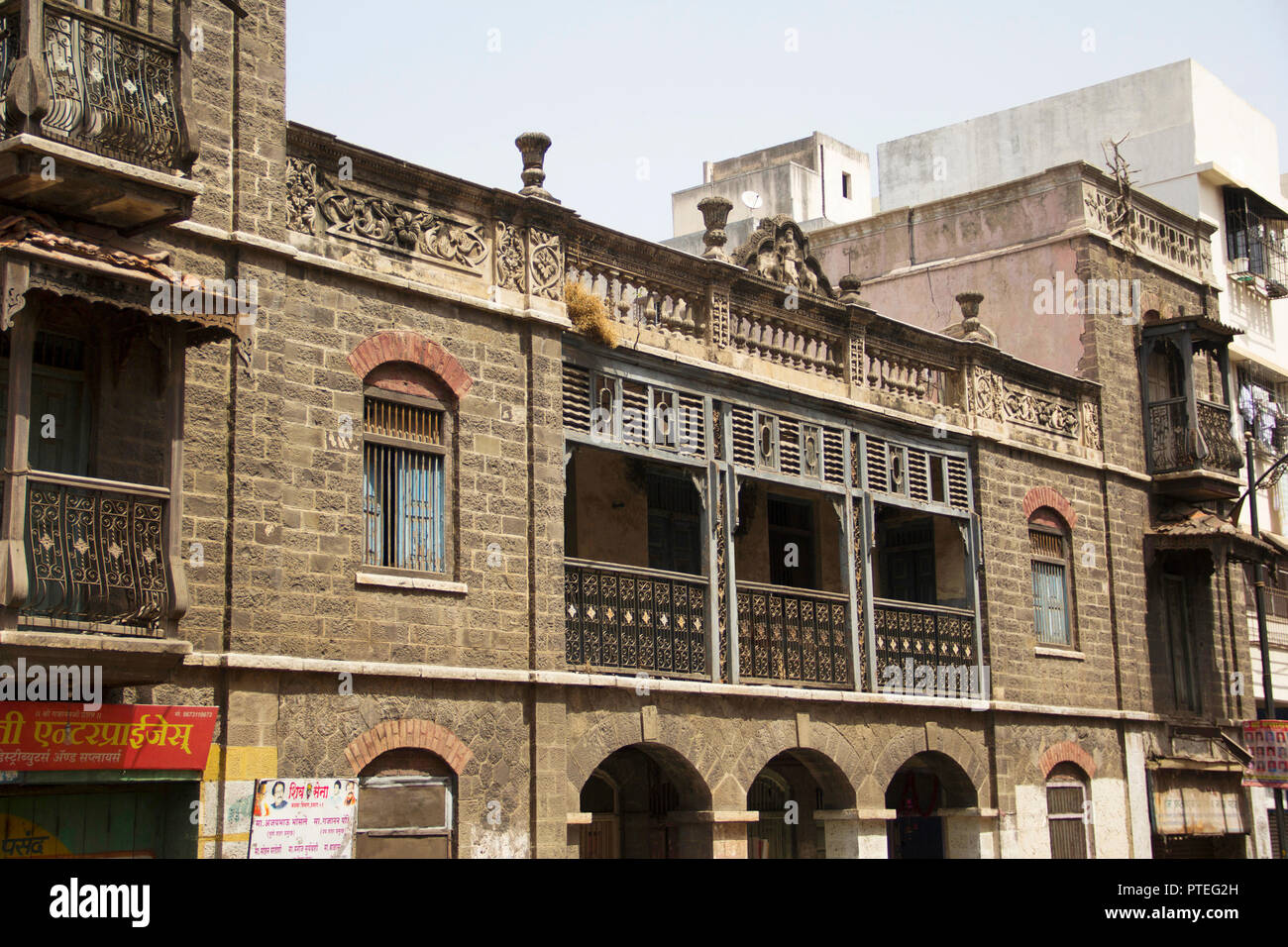 A view of old stone building with windows and balcony at Guruvar Peth, Pune Stock Photo
