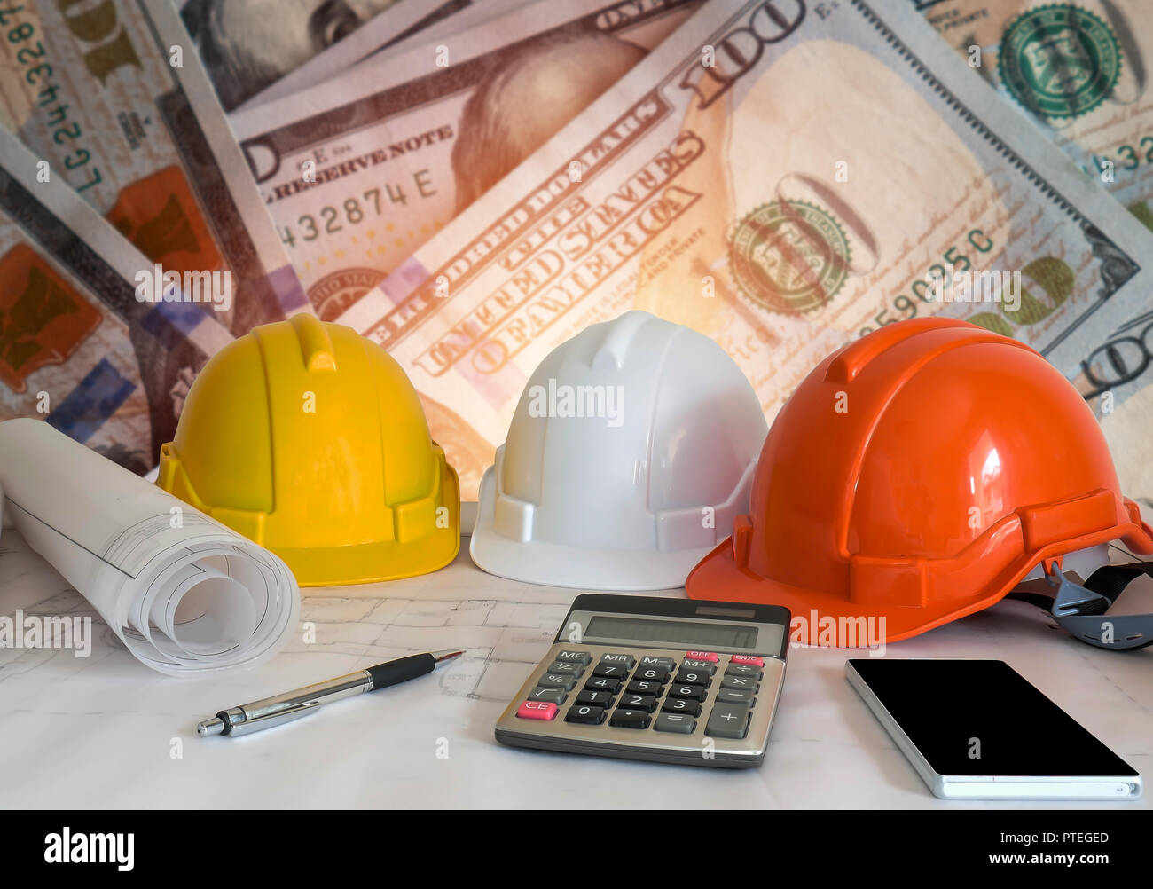 Architectural blueprint with safety helmet and tools on blur dollar money background. Stock Photo