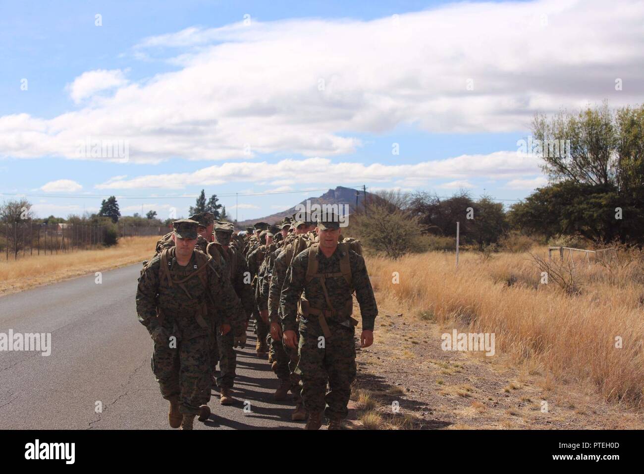 Capt. Joshua A. Bales, assigned to 3rd Battalion, 25th Marines, leads his Marines on a three mile conditioning hike as part of Shared Accord 17 (SA17) at South African Army Combat Training Center, Lohatla, South Africa, July 16, 2017. SA17 is a Joint bi-lateral Field Training Exercise with our South African partners focused on Peace Keeping Operations designed to exercise participants’ capability and capacity to conduct African Union / United Nations mandated Peace Keeping Operations. Stock Photo
