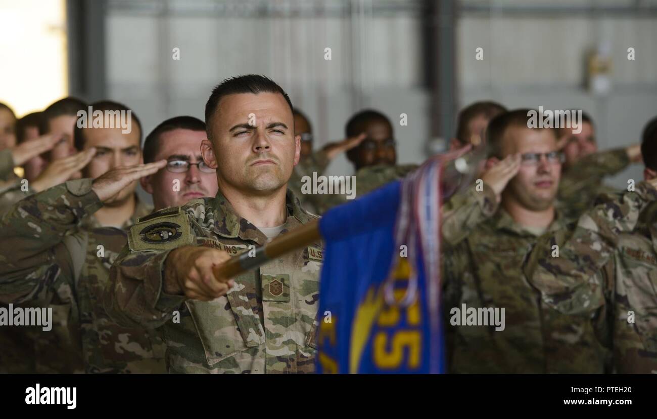 Master Sgt. Justin Mullins, the 455th Expeditionary Aircraft Maintenance Squadron first sergeant, holds the 455th EAMXS guidon during the singing of the national anthem at Bagram Airfield, Afghanistan, July 14, 2017. Mullins served as the guidon bearer during the 455th EAMXS change of command ceremony, where Lt. Col. Sean Goode relinquished command to Lt. Col. Robert Kongaika. Stock Photo