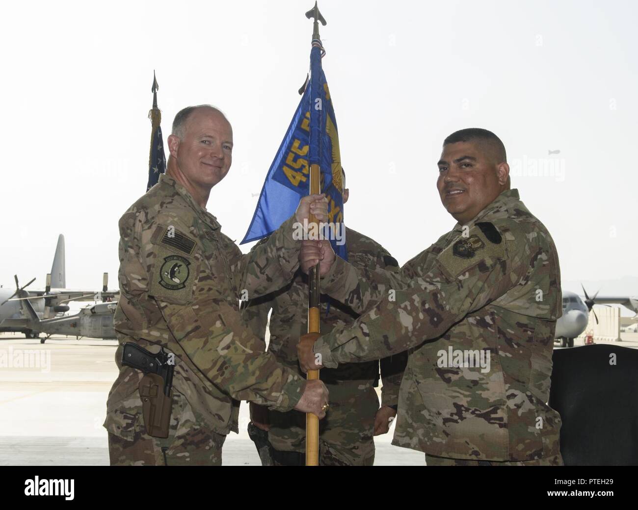Lt. Col. Robert Kongaika, right, the incoming 455th Expeditionary Aircraft Maintenance Squadron commander, receives the 455th EAMXS guidon from Col. Tim Trimmell, the 455th Expeditionary Maintenance Group commander, during a change of command at Bagram Airfield, July 14, 2017. Kongaika previously served as the 31st Aircraft Maintenance Squadron commander at Aviano Air Base, Italy. Stock Photo