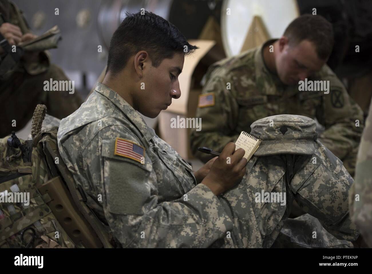 U.S. Army Spc. Saul Hernandez, infantryman, Alpha Company, 3rd Battalion, 172nd Infantry Regiment, 86th Infantry Brigade Combat Team (Mountain), Vermont National Guard, take notes while being briefed operations orders at Camp Ethan Allen Training Site, Jericho, Vt., July 15, 2017.  The Soldiers were preparing for a squad training exercise that included patrolling, crossing vertical danger areas and squad attacks. Stock Photo