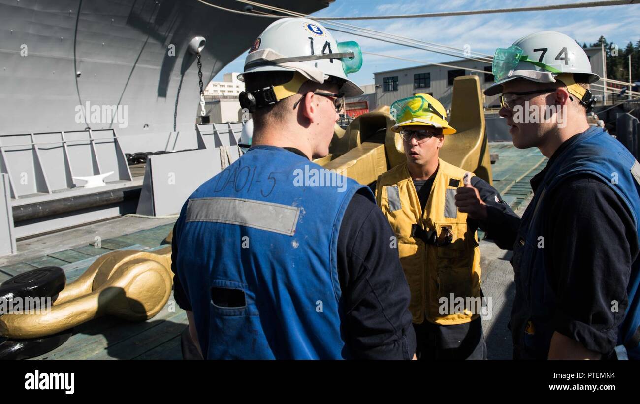 Washington (July 14, 2017) Boatswain's Mate 2nd Class Brian Miranda, from Juncos, Puerto Rico, briefs Seaman Aaron Miller, from Seattle (left), and Seaman Dylan Topham, from Santa Maria, California, on safety procedures before reattaching USS John C. Stennis' (CVN 74) anchor. John C. Stennis is conducting a planned incremental availability (PIA) at Puget Sound Naval Shipyard and Intermediate Maintenance Facility, during which the ship is undergoing scheduled maintenance and upgrades. Stock Photo
