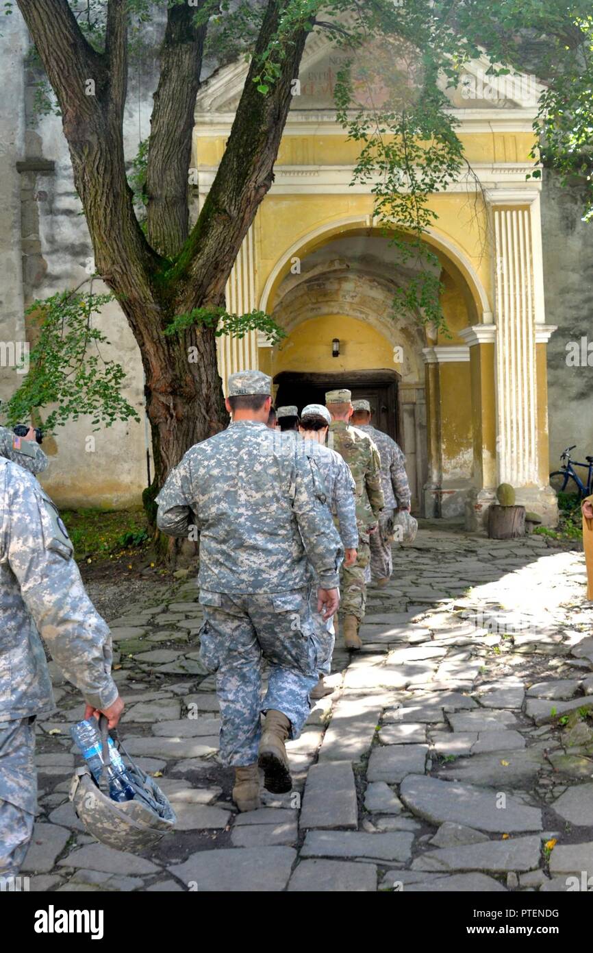 N.C. National Guard Chaplain Cpt. Rodney Dettmer works with Romanian Chaplain offering 5-113th Field Artillery Regiment Soldiers the opportunity to visit a local 800-year-old church and to commune with local parishioners during their Sunday mass in the town of Cincu, Romania on 17 July, 2017.  Soldiers were given a once in a lifetime opportunity to explore the historic church and to learn more about the history of the local town they have called home for Exercise Saber Guardian '17. Stock Photo