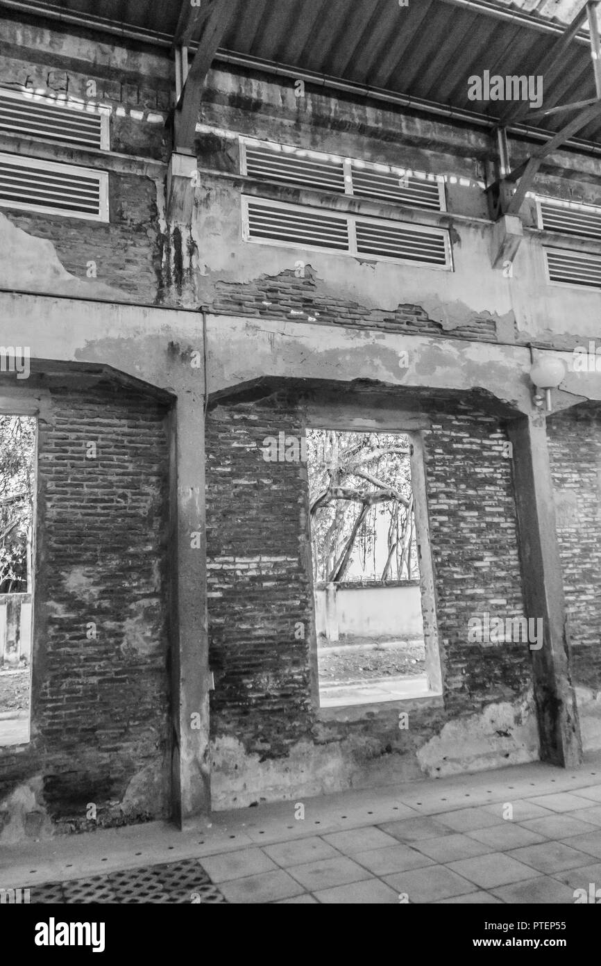 The ruins of an old abandoned factory. Perspective of abandoned warehouse from the inside with translucent roof and concrete structure. Stock Photo