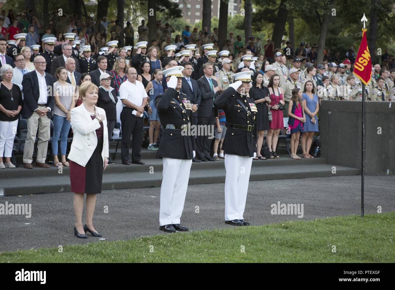 From left, The Honorable Kay Granger, United States representative, Texas’ 12th Congressional District, U.S. Marine Corps Lt. Gen. Steven R. Rudder, deputy commandant, Aviation and Col. Tyler J. Zagurski, commanding officer, Marine Barracks Washington stand for honors during a sunset parade at the Marine Corps War Memorial, Arlington, Va., July 18, 2017. Sunset parades are held as a means of honoring senior officials, distinguished citizens and supporters of the Marine Corps. Stock Photo