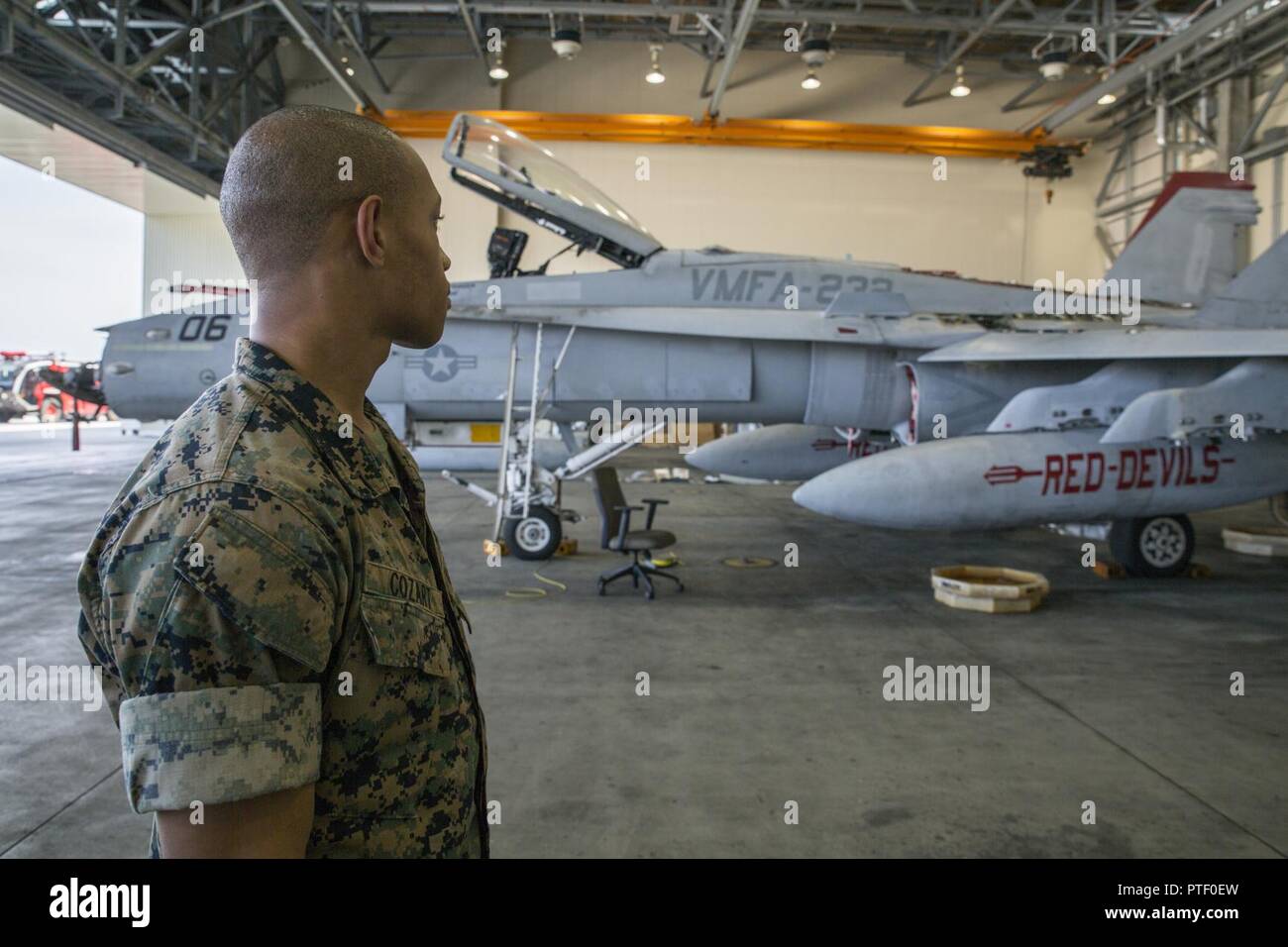 U.S. Marine Corps Pfc. Christian Cozart, an aircraft rescue firefighter with Headquarters and Headquarters Squadron, visits a display of an F/A-18C Hornet at Marine Corps Air Station Iwakuni, Japan, July 19, 2017. Aircraft Rescue and Firefighting Marines visited the display to familiarize themselves with the aircraft so they can be more effective in emergency situations. Stock Photo