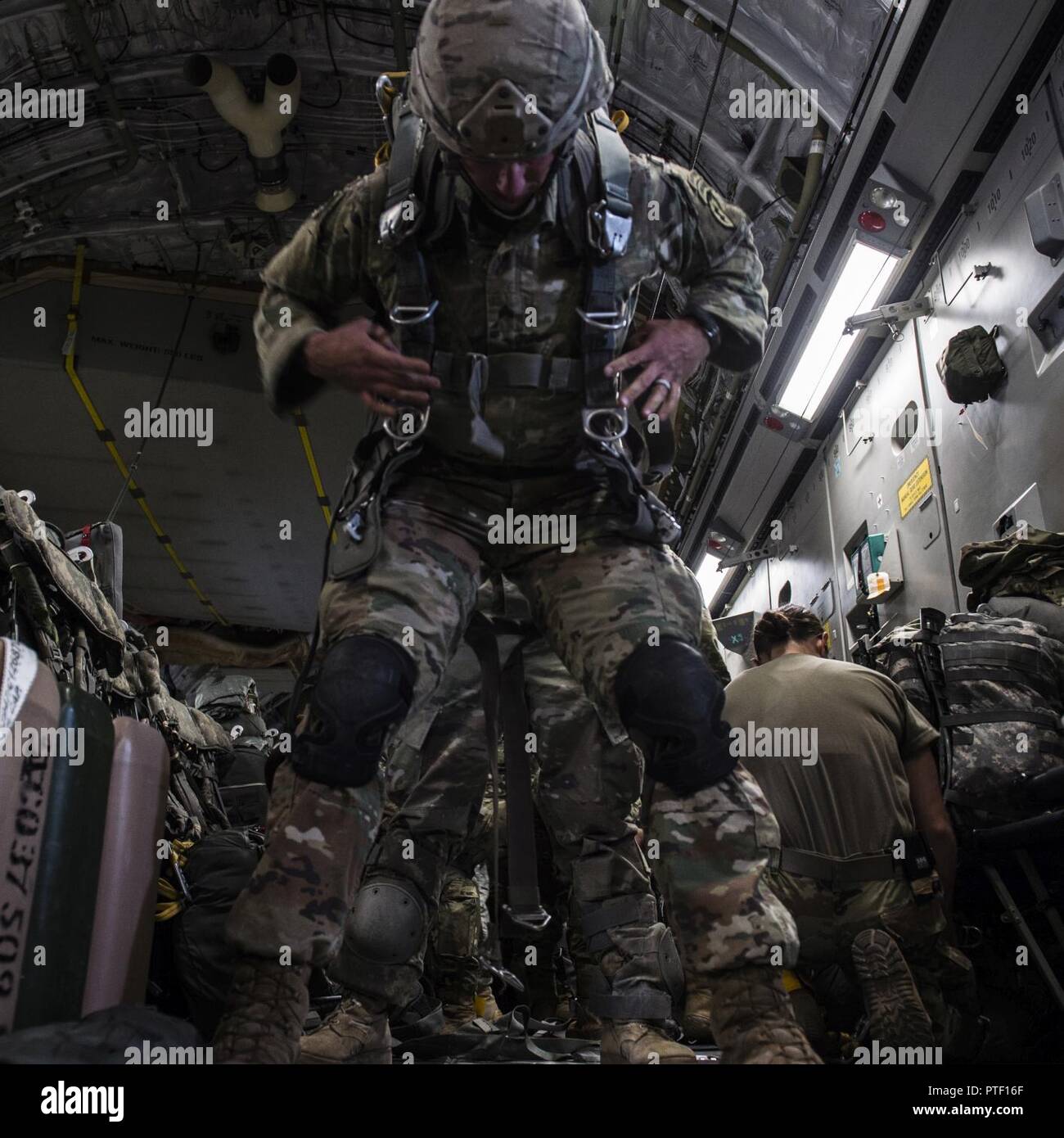 U.S. Army Sgt. Zachary Hudson, airborne paratrooper from the 4th Brigade 25th Infantry division, rigs his gear to prepare for drop onboard a U.S. Air Force C-17 from Joint Base Charleston, S.C., July 12, 2017 to participate in Exercise Talisman Saber 2017. The purpose of TS17 is to improve U.S.-Australian combat readiness, increase interoperability, maximize combined training opportunities and conduct maritime prepositioning and logistics operations in the Pacific. TS17 also demonstrates U.S. commitment to its key ally and the overarching security framework in the Indo Asian Pacific region. Stock Photo