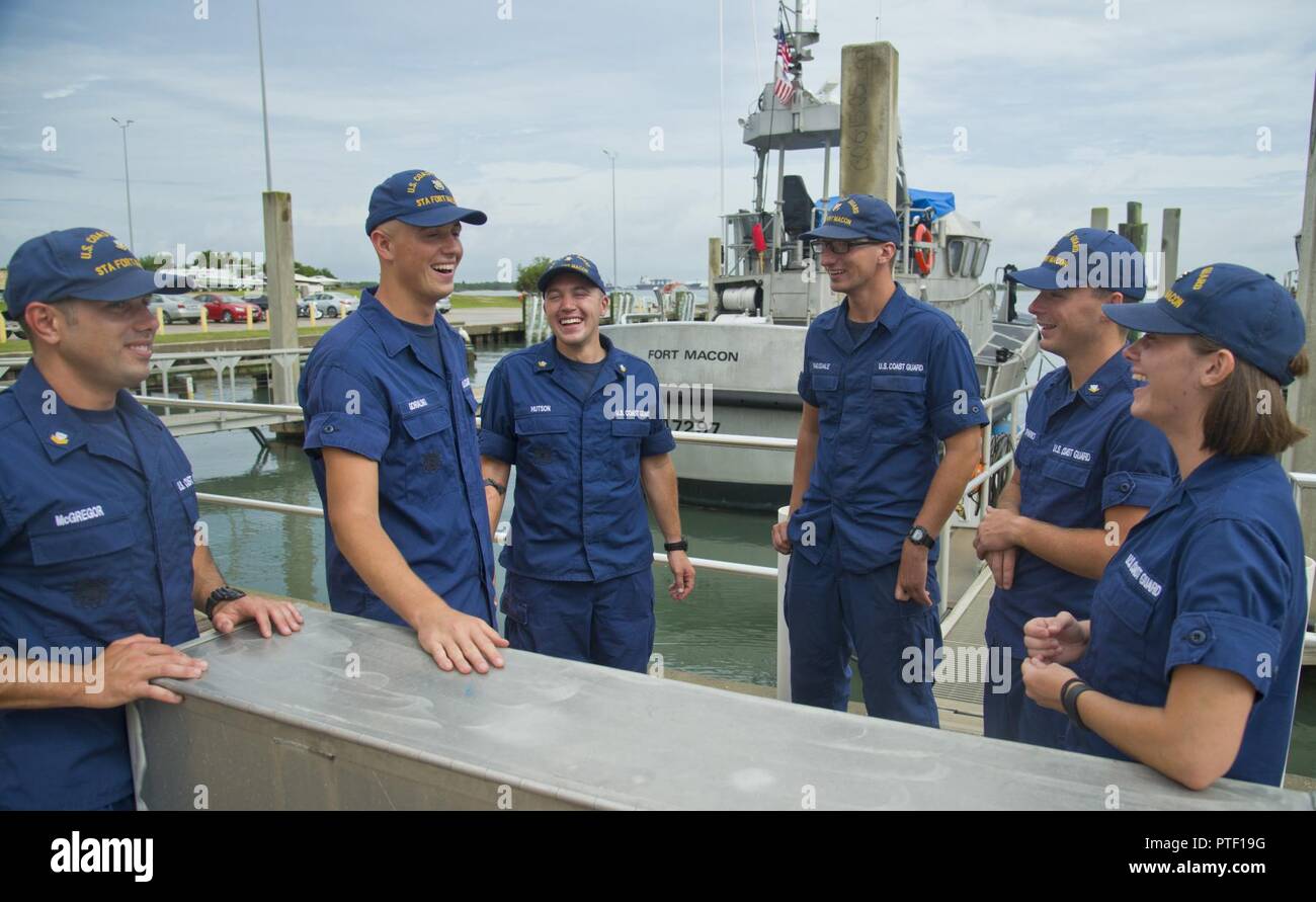 Petty Officer 2nd Class Tyler McGregor (left to right), Seaman Crewe Goralski, Petty Officer 2nd Class Zane Hutson, Fireman Samuel Ragsdale, Petty Officer 3rd Class Michael Sparks and Fireman Jordan Markland, Coast Guardsmen at Station Fort Macon, recall a recent rescue at the station, July 10, 2017. Sparks and Ragsdale were rescued by the others after a diving trip gone wrong a few days earlier. Stock Photo