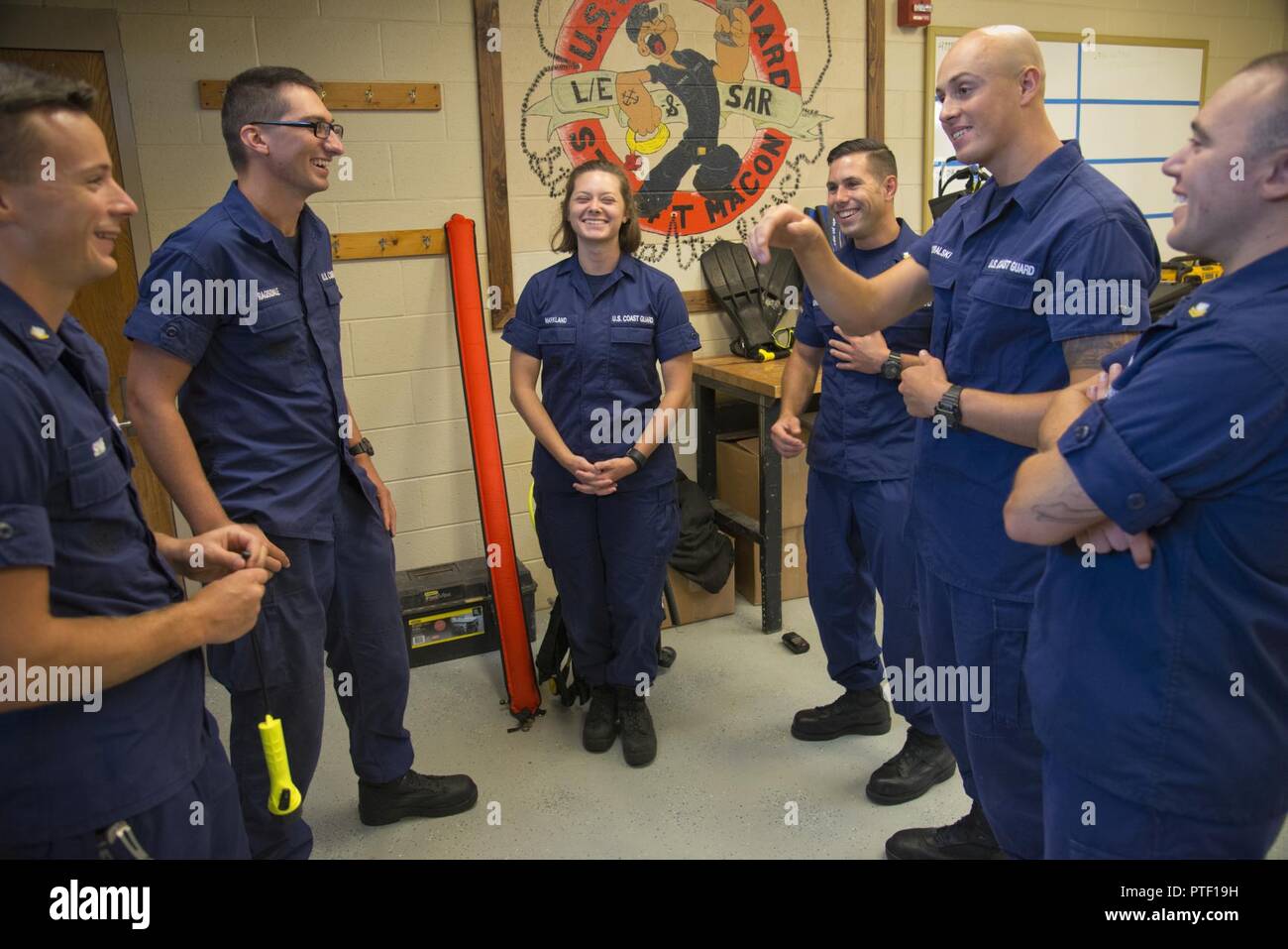 Petty Officer 3rd Class Michael Sparks (left to right), Fireman Samuel Ragsdale, Fireman Jordan Markland, Petty Officer 2nd Class Tyler McGregor, Seaman Crewe Goralski and Petty Officer 2nd Class Zane Hutson reunite at Station Fort Macon, North Carolina, July 10, 2017. Sparks and Ragsdale were rescued by the others July 6 after a diving incident where the two were stranded and clung to the orange safety sausage (seen center) to stay together. Stock Photo
